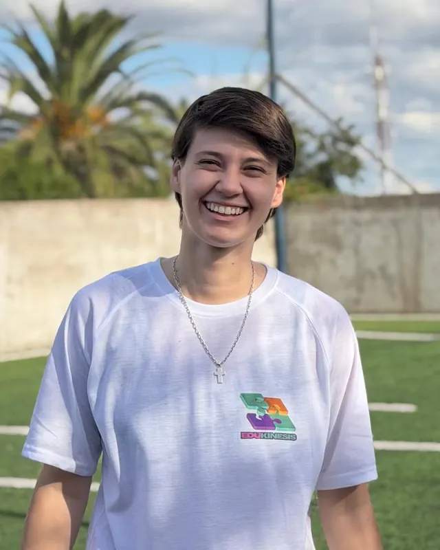 Lucía Albornoz, recreadora y estudiante de educación física de EduKinesis, sonriendo en la cancha