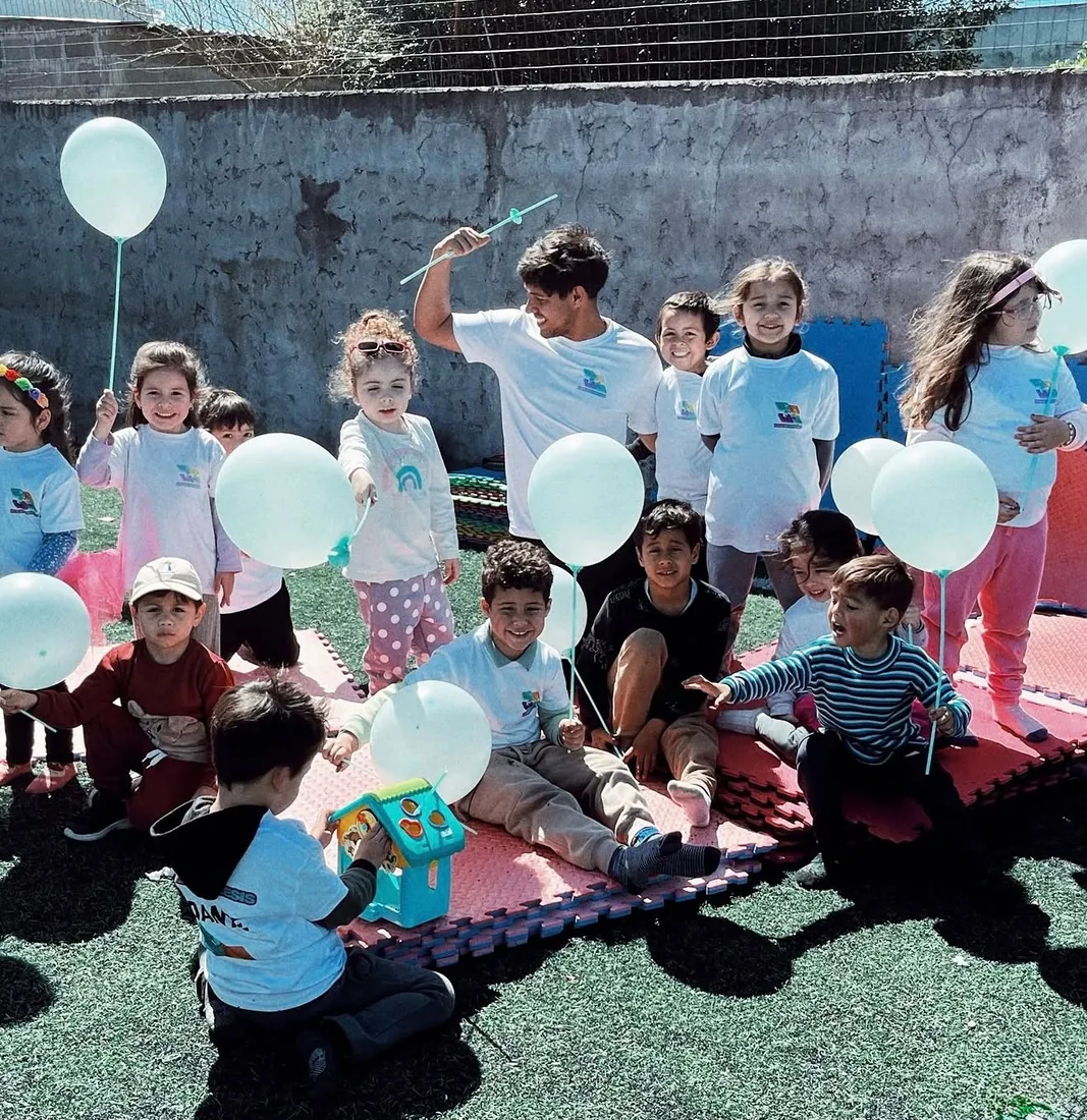 Grupo de niños celebrando con globos en una actividad al aire libre