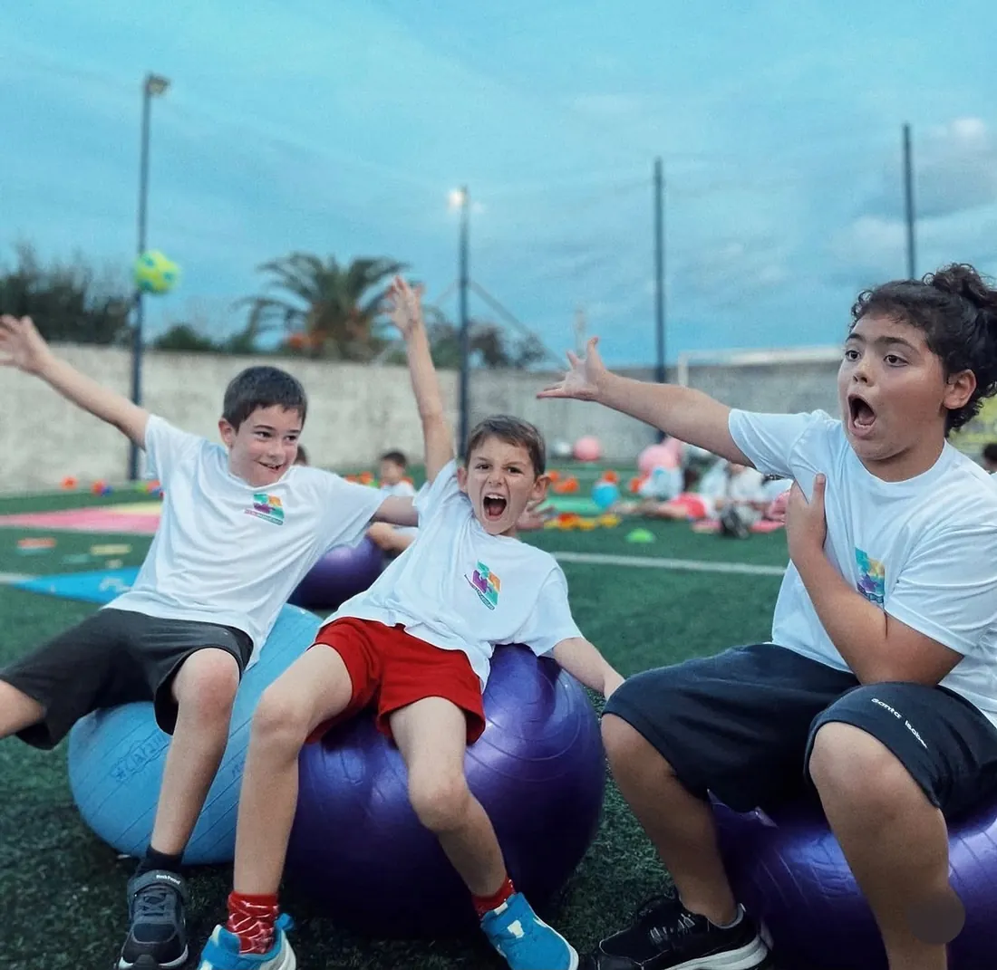 Niños en juegos grupales y cooperativos en la cancha al aire libre de EduKinesis