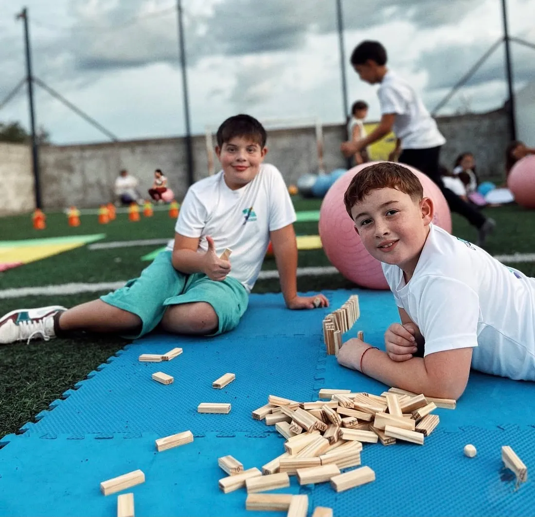 Niños con pelotas de gimnasia en la cancha al aire libre