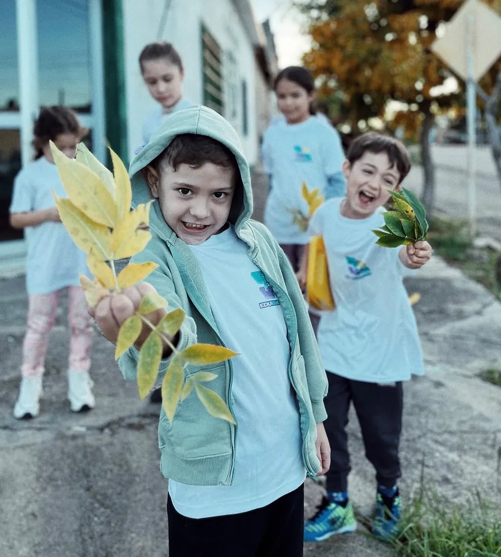 Niños mostrando manos de papel hechas en el taller de arte y expresión plástica